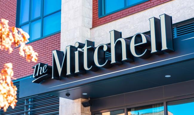 Settle into comfort at The Mitchell a sign on the side of a building