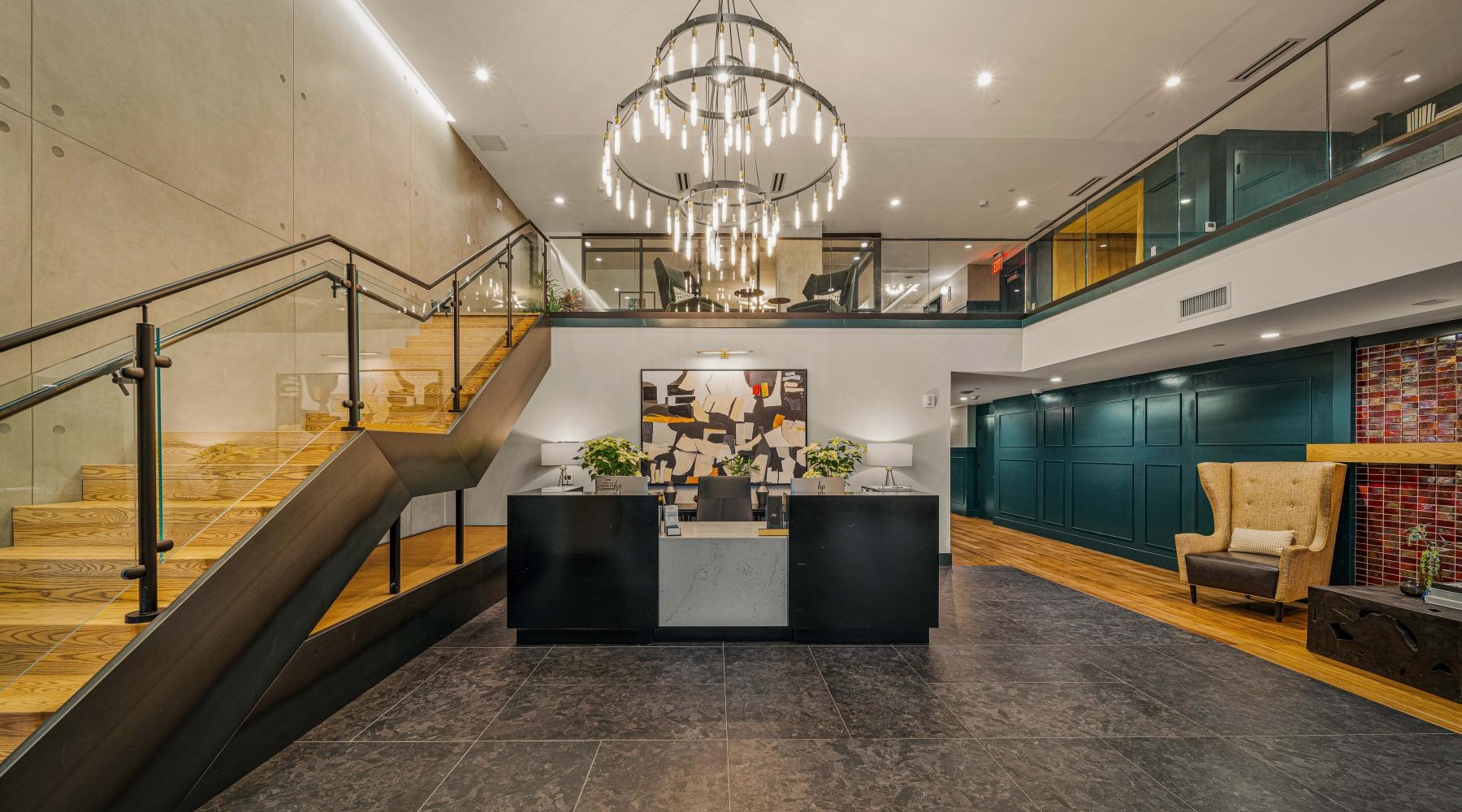 Settle into comfort at The Mitchell a large room with a large chandelier and a staircase